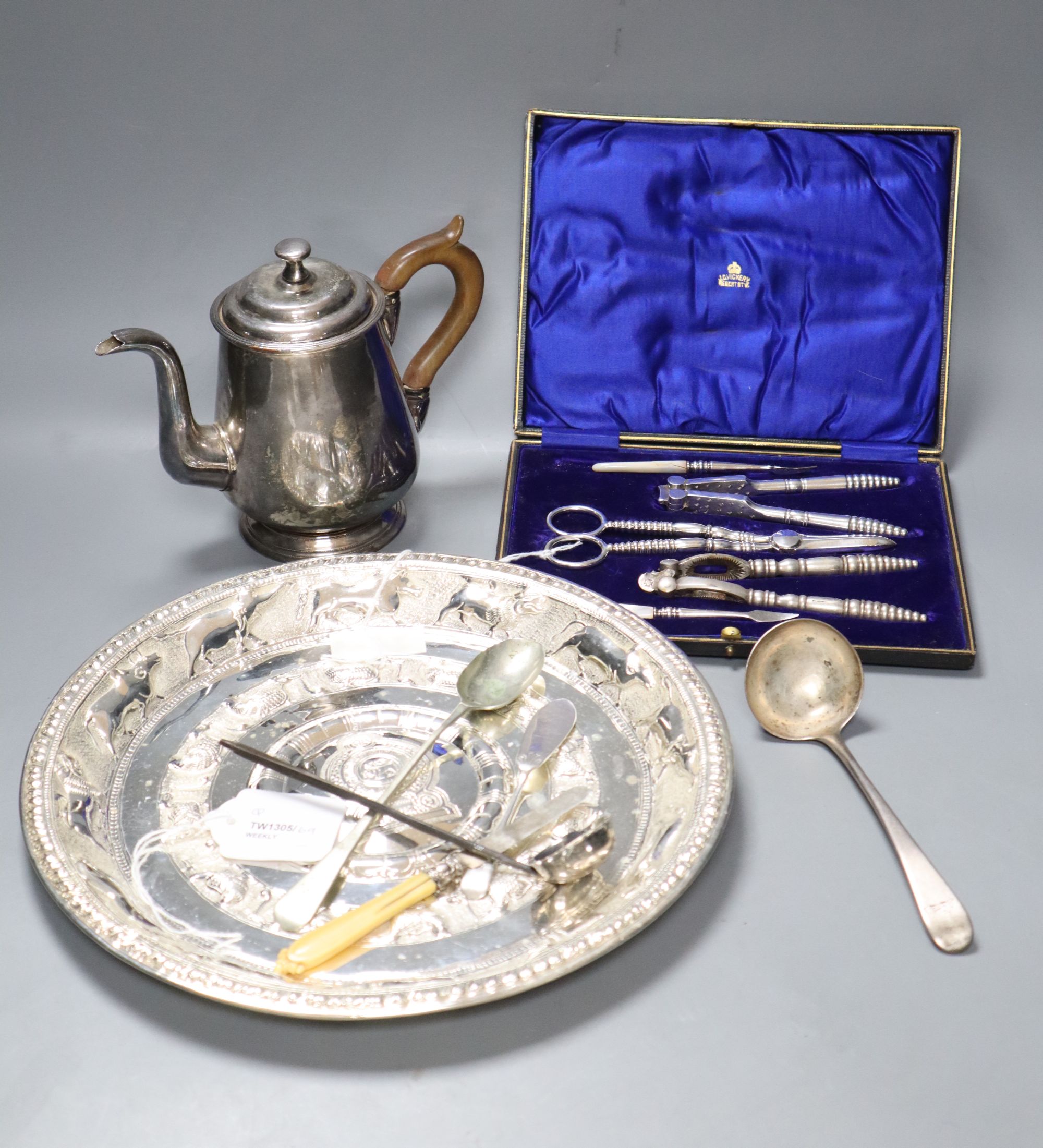 An Eastern embossed plated tray, a cased plated nut and grape set, a plated coffee pot, a silver sauce ladle and sundries